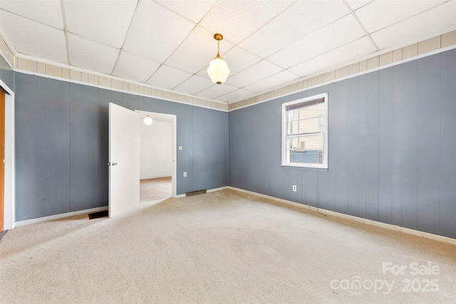 217 S Highland St, Gastonia, NC 28052 - spare room with carpet flooring, a paneled ceiling, baseboards, and wooden walls
