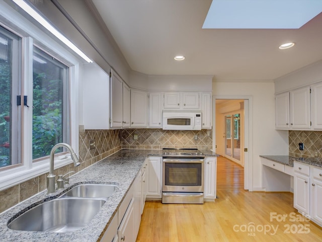 8 Sunrise Point Rd, Lake Wylie, SC 29710 - kitchen with stainless steel electric range, white microwave, a sink, decorative backsplash, and light wood finished floors