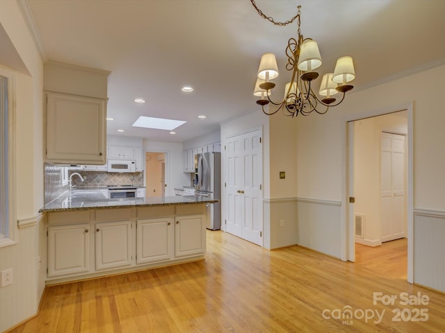 8 Sunrise Point Rd, Lake Wylie, SC 29710 - kitchen with appliances with stainless steel finishes, light wood finished floors, a skylight, tasteful backsplash, and recessed lighting