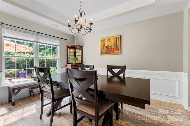 16018 Hollingbourne Rd, Huntersville, NC 28078 - dining area with a chandelier, light wood-type flooring, a tray ceiling, and a wainscoted wall