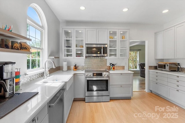 16018 Hollingbourne Rd, Huntersville, NC 28078 - kitchen with appliances with stainless steel finishes, a sink, light wood-style flooring, open shelves, and light countertops