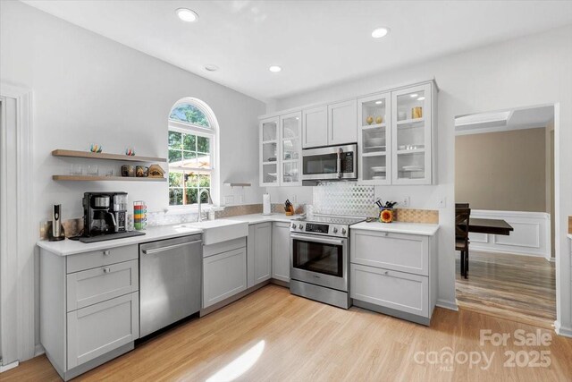 16018 Hollingbourne Rd, Huntersville, NC 28078 - kitchen featuring appliances with stainless steel finishes, a sink, gray cabinetry, light wood-type flooring, and light countertops