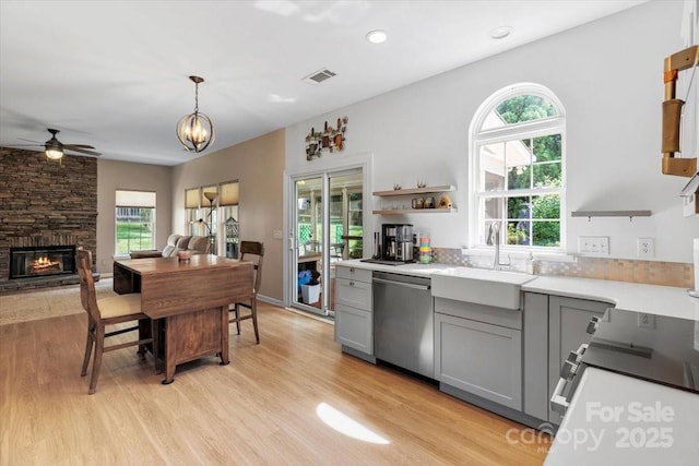 16018 Hollingbourne Rd, Huntersville, NC 28078 - kitchen featuring stainless steel dishwasher, gray cabinetry, a sink, a ceiling fan, and light wood-type flooring