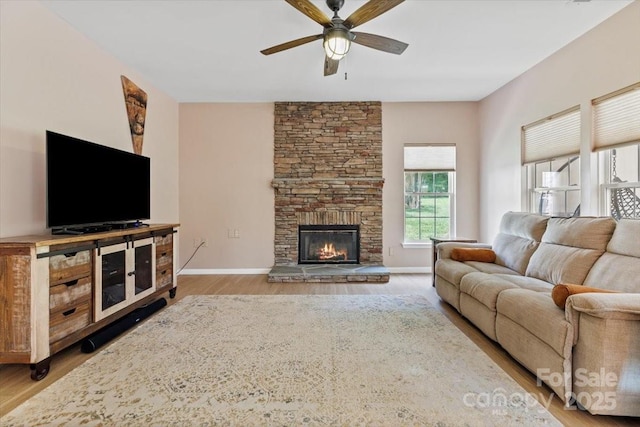 16018 Hollingbourne Rd, Huntersville, NC 28078 - living area with ceiling fan, wood finished floors, a stone fireplace, and baseboards