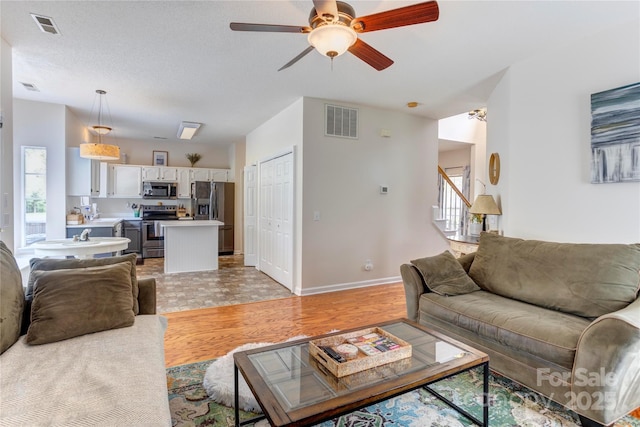 2024 Stonewyck Ave, Kannapolis, NC 28081 - living area with light wood finished floors, a ceiling fan, stairway, and baseboards