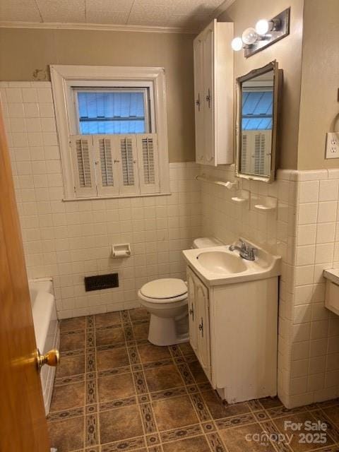 8000 Chapman St, Charlotte, NC 28216 - full bath with tile walls, tile patterned flooring, crown molding, toilet, and vanity