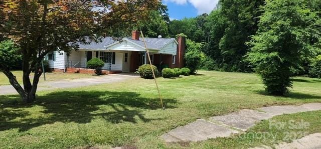 8000 Chapman St, Charlotte, NC 28216 - single story home with a chimney, a front lawn, a porch, and concrete driveway