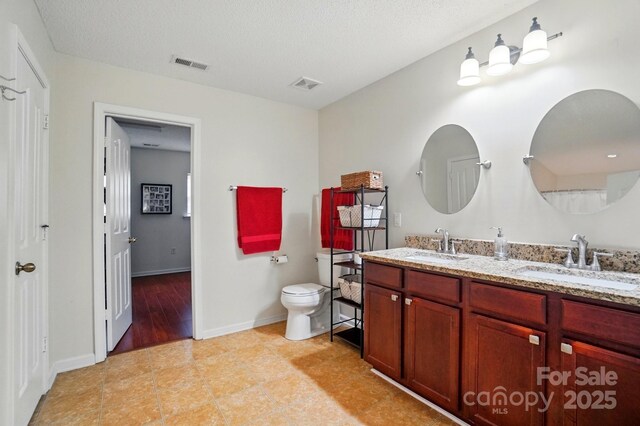 512 Nanny Point Dr, Monroe, NC 28110 - full bathroom featuring toilet, double vanity, and baseboards