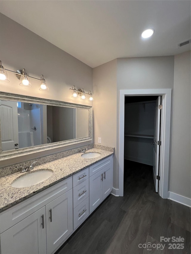1987 Robert Rufty Ln, Catawba, NC 28609 - bathroom featuring wood finished floors, double vanity, a shower, and a walk in closet