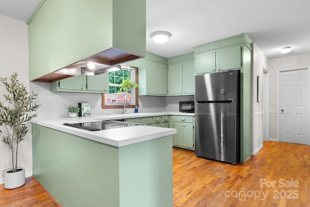 139 Pleasant Garden Dr, Taylorsville, NC 28681 - kitchen with black appliances, green cabinets, a peninsula, a sink, and a textured ceiling