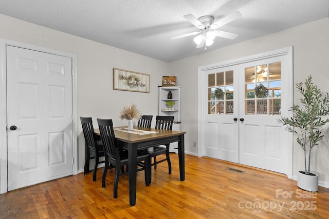 139 Pleasant Garden Dr, Taylorsville, NC 28681 - dining room featuring light wood finished floors, a ceiling fan, a textured ceiling, and baseboards