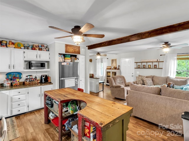 49 Trimont Mountain Trl, Franklin, NC 28734 - kitchen featuring appliances with stainless steel finishes, ceiling fan, white cabinets, light wood-style floors, and beam ceiling