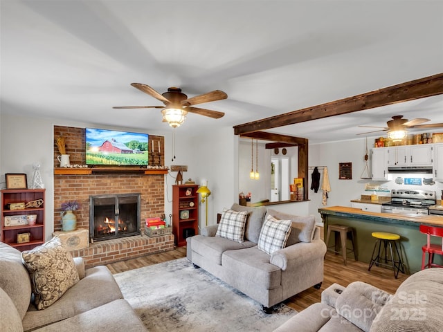 49 Trimont Mountain Trl, Franklin, NC 28734 - living area with a ceiling fan, wood finished floors, and a brick fireplace