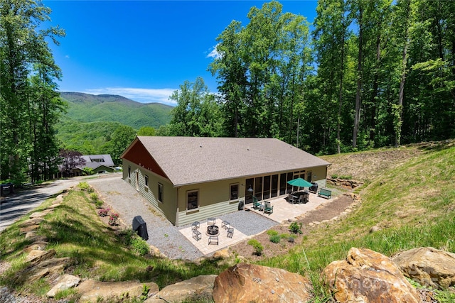33 Freedom Dr, Waynesville, NC 28786 - rear view of house with an outdoor fire pit, a patio area, a mountain view, and roof with shingles