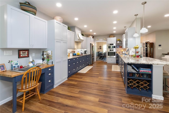 33 Freedom Dr, Waynesville, NC 28786 - kitchen with open shelves, stainless steel appliances, blue cabinets, dark wood-style floors, and custom exhaust hood