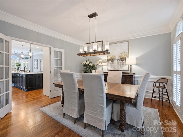 16308 Woolwine Rd, Charlotte, NC 28278 - dining room with a chandelier, ornamental molding, healthy amount of natural light, wood finished floors, and a wainscoted wall