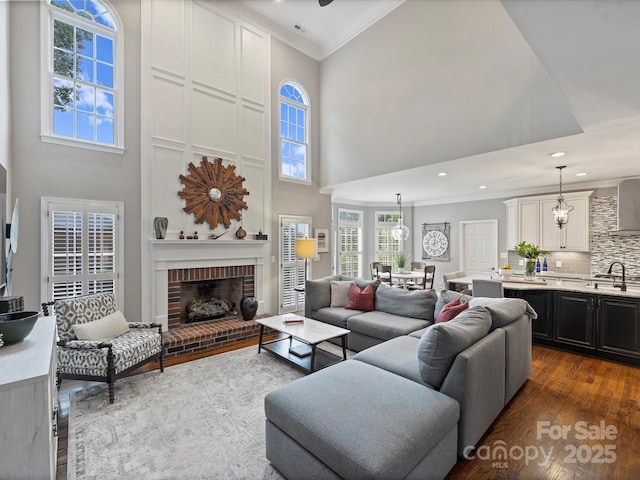 16308 Woolwine Rd, Charlotte, NC 28278 - living room with a towering ceiling, wood finished floors, crown molding, a fireplace, and recessed lighting