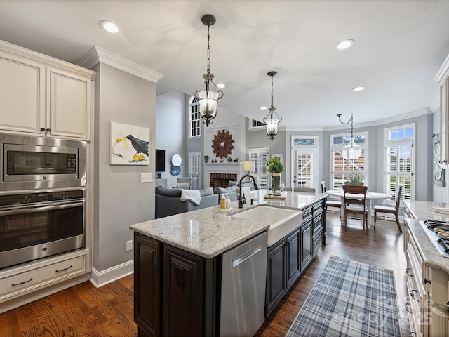 16308 Woolwine Rd, Charlotte, NC 28278 - kitchen with stainless steel appliances, a sink, ornamental molding, light stone counters, and pendant lighting