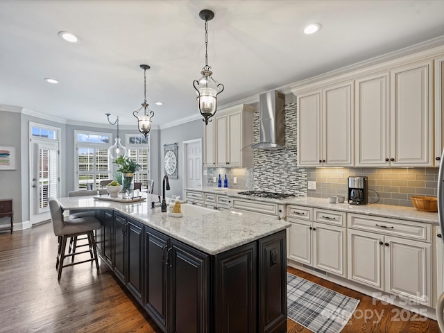 16308 Woolwine Rd, Charlotte, NC 28278 - kitchen featuring wall chimney range hood, ornamental molding, a kitchen island with sink, tasteful backsplash, and dark wood-type flooring