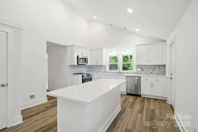 615 Irish Potato Rd, Concord, NC 28025 - kitchen with stainless steel appliances, a sink, tasteful backsplash, dark wood-style floors, and vaulted ceiling