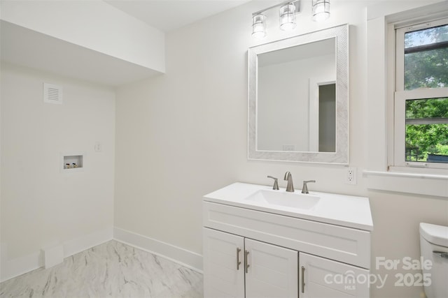 615 Irish Potato Rd, Concord, NC 28025 - half bath featuring vanity, toilet, plenty of natural light, and marble look tiles