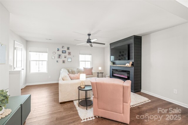 5023 Daybell St, Charlotte, NC 28214 - living area with wood finished floors, a large fireplace, a ceiling fan, and baseboards