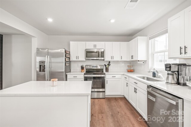 5023 Daybell St, Charlotte, NC 28214 - kitchen featuring stainless steel appliances, a sink, backsplash, white cabinetry, and recessed lighting