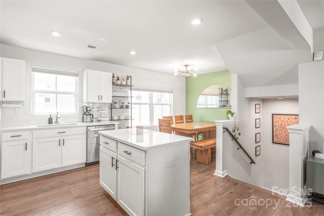 5023 Daybell St, Charlotte, NC 28214 - kitchen with stainless steel dishwasher, a sink, decorative backsplash, white cabinetry, and light wood finished floors