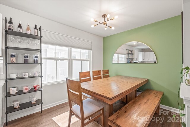 5023 Daybell St, Charlotte, NC 28214 - dining area featuring a chandelier, wood finished floors, and baseboards
