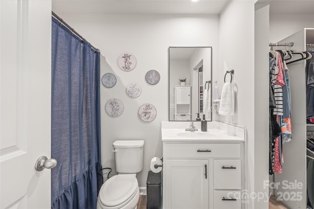 5023 Daybell St, Charlotte, NC 28214 - bathroom featuring toilet, vanity, a walk in closet, and baseboards