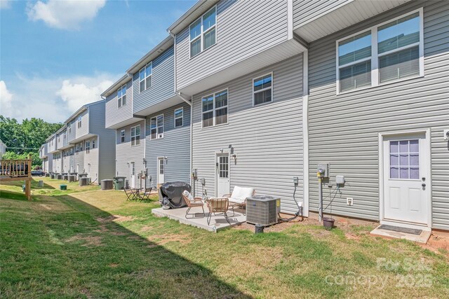 5023 Daybell St, Charlotte, NC 28214 - back of property featuring central AC, a lawn, a patio area, and a residential view