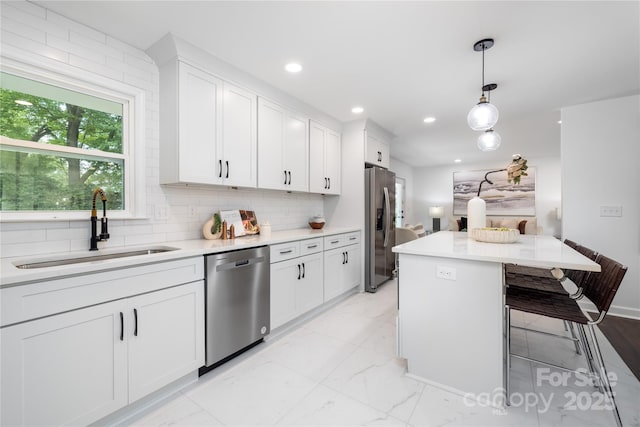 4017 Sulkirk Rd, Charlotte, NC 28210 - kitchen featuring appliances with stainless steel finishes, a sink, white cabinetry, light marble finish flooring, and recessed lighting