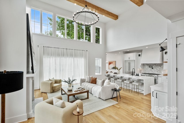 621 Poindexter Dr, Charlotte, NC 28209 - living area with a chandelier, a towering ceiling, light wood finished floors, and beam ceiling