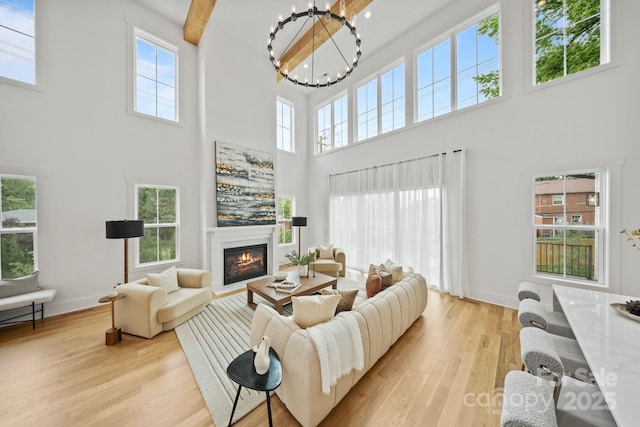 621 Poindexter Dr, Charlotte, NC 28209 - living area featuring a towering ceiling, a chandelier, a glass covered fireplace, wood finished floors, and baseboards