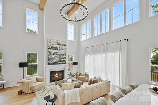 621 Poindexter Dr, Charlotte, NC 28209 - living room with a high ceiling, wood finished floors, a chandelier, healthy amount of natural light, and a premium fireplace