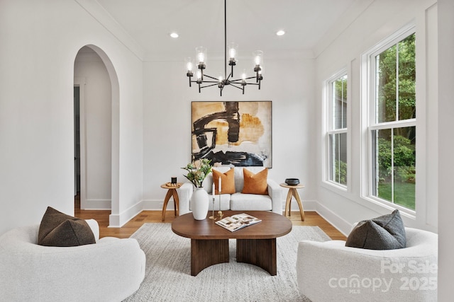 621 Poindexter Dr, Charlotte, NC 28209 - living area with arched walkways, healthy amount of natural light, wood finished floors, a chandelier, and crown molding
