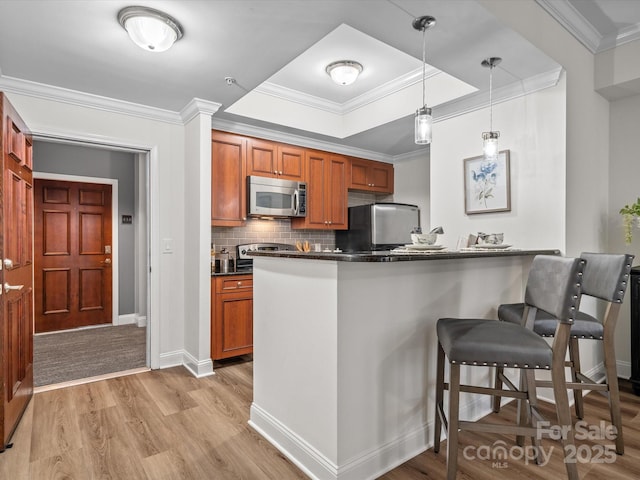 300 W 5th St Unit 433, Charlotte, NC 28202 - kitchen with stainless steel appliances, dark countertops, a kitchen bar, light wood finished floors, and a raised ceiling