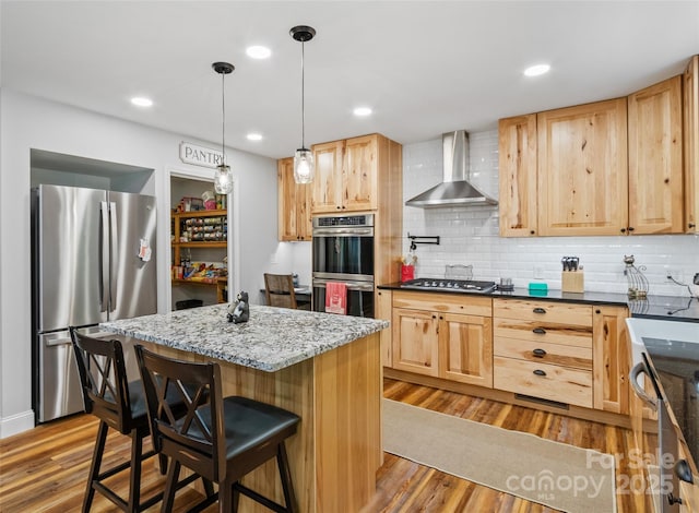 1493 Upper Browns Creek Rd, Burnsville, NC 28714 - kitchen with wall chimney range hood, stainless steel appliances, light brown cabinets, wood finished floors, and recessed lighting