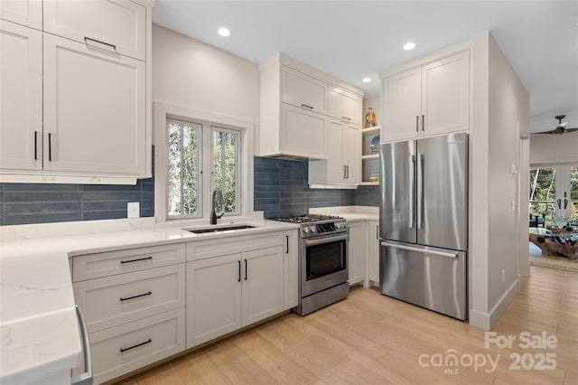 1081 Hicks Rd Unit B, Highlands, NC 28741 - kitchen with stainless steel appliances, a sink, light wood finished floors, open shelves, and light stone counters