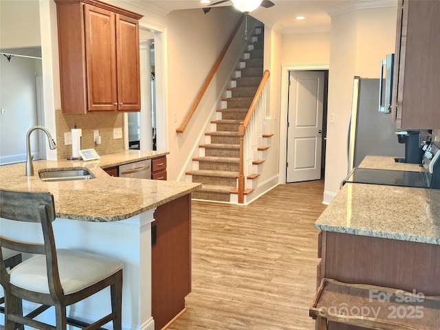 1108 Tarram Ct Unit 12, Lancaster, SC 29720 - kitchen featuring a sink, a kitchen breakfast bar, ornamental molding, decorative backsplash, and brown cabinets