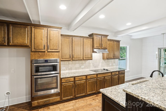 8521 Aspen Ct, Charlotte, NC 28227 - kitchen featuring beamed ceiling, double oven, light wood-style floors, baseboards, and decorative backsplash