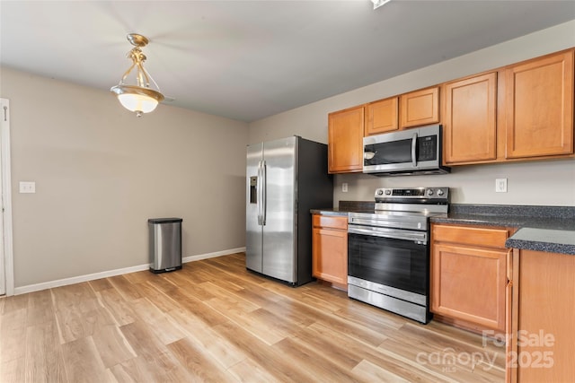 3996 Heather View Ln, Winston Salem, NC 27127 - kitchen featuring stainless steel appliances, dark countertops, light wood-style flooring, and baseboards