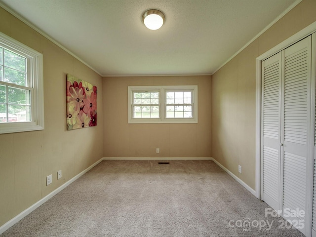 2666 Hill Ln, Gastonia, NC 28054 - unfurnished bedroom featuring crown molding, carpet floors, baseboards, and a closet