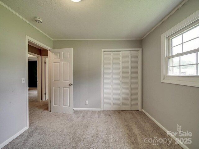 2666 Hill Ln, Gastonia, NC 28054 - unfurnished bedroom featuring crown molding, carpet floors, a closet, and baseboards