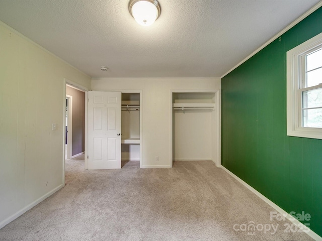 2666 Hill Ln, Gastonia, NC 28054 - unfurnished bedroom featuring two closets, a textured ceiling, carpet floors, and baseboards