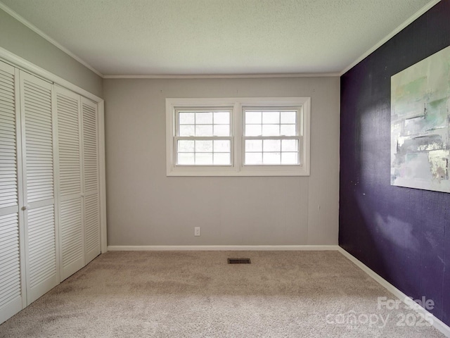2666 Hill Ln, Gastonia, NC 28054 - unfurnished bedroom featuring crown molding, carpet flooring, a textured ceiling, a closet, and baseboards