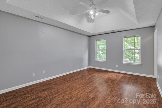 8120 Vermilion Dr, Charlotte, NC 28215 - empty room featuring a raised ceiling, dark wood-style floors, ceiling fan, baseboards, and a textured ceiling