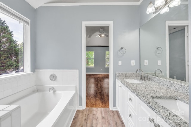 8120 Vermilion Dr, Charlotte, NC 28215 - full bathroom featuring wood finished floors, double vanity, a bath, ornamental molding, and a ceiling fan