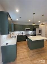 320 Lawrence Gray Rd, Charlotte, NC 28262 - kitchen with stainless steel appliances, light countertops, decorative light fixtures, a sink, and light wood finished floors