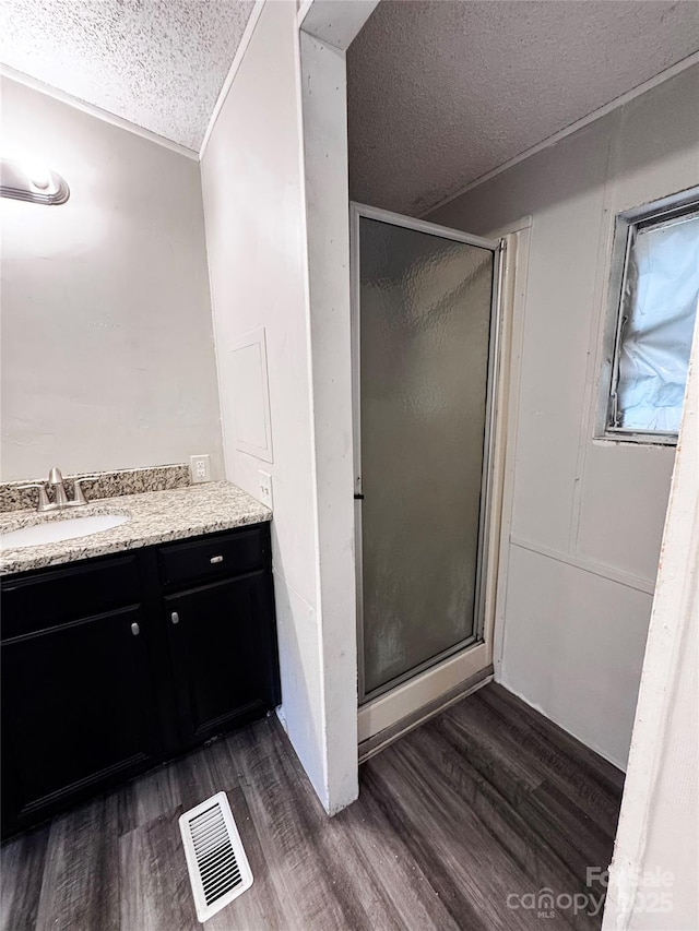 1145 Daniel Rd, Mocksville, NC 27028 - bathroom with a textured ceiling, a stall shower, vanity, and wood finished floors